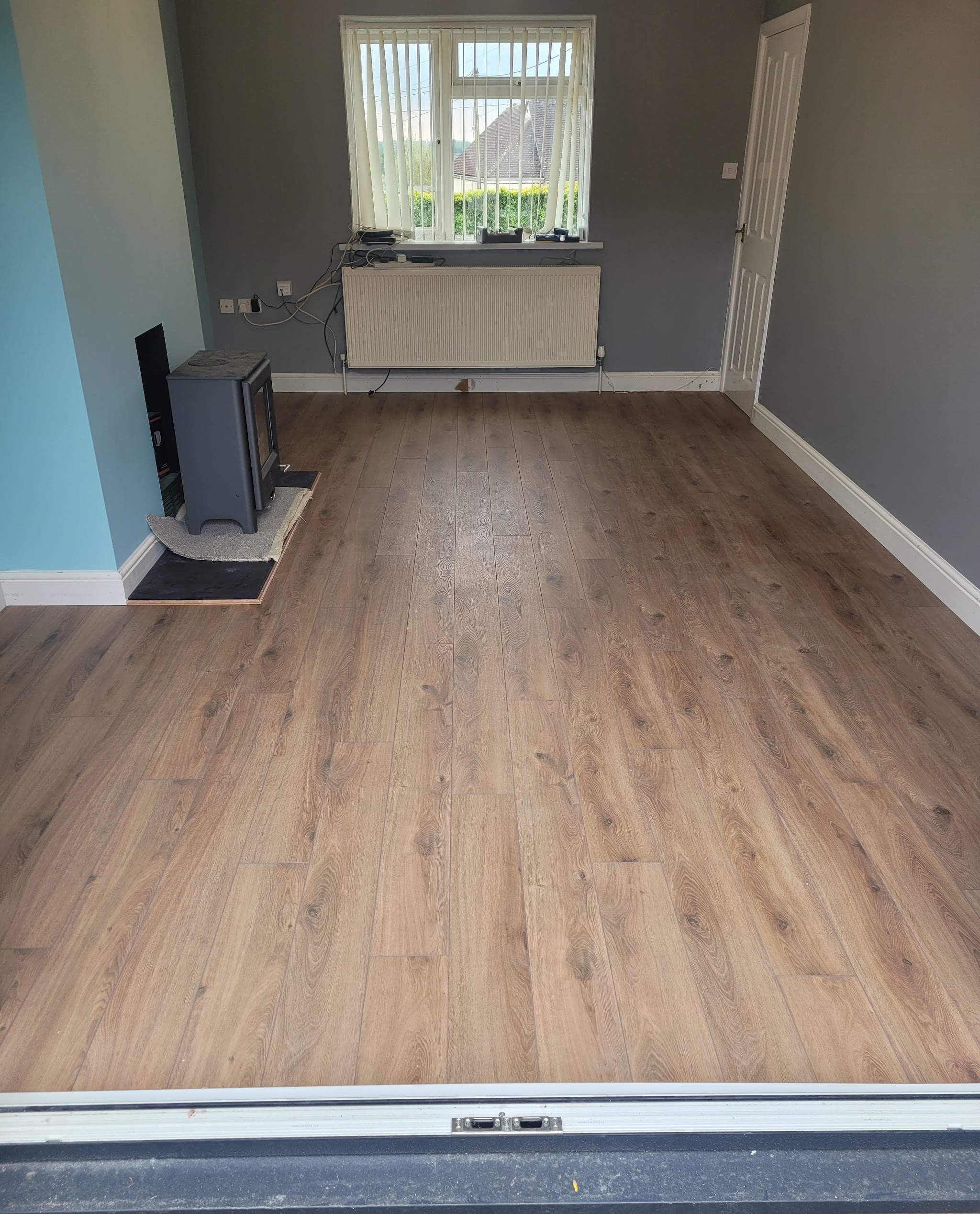 New wood-effect flooring laid through an empty room