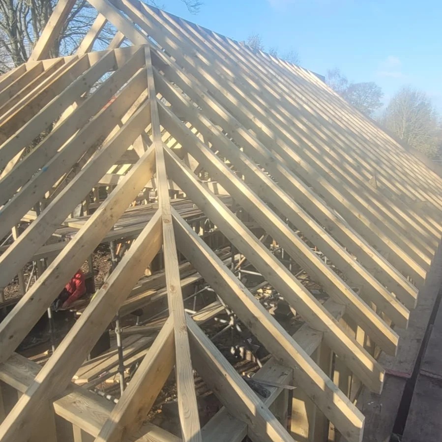 A timber cut roof in progress against a blue sky